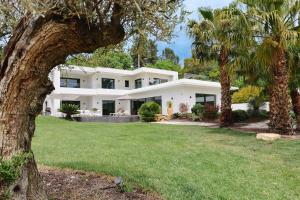 a white house with palm trees in front of it at Villa contemporaine de luxe in Aix-en-Provence