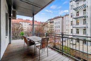 a balcony with a table and chairs on a balcony at Apartments I 5 Min to Millennium City Mall and Handelskai U6 in Vienna