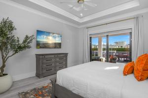 a bedroom with a bed and a dresser and a window at Marco Luxe Retreat Waterfront in Marco Island +61 photos