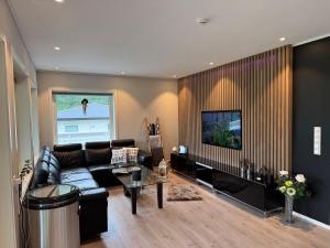 a living room with a couch and a tv at Loen Panorama View in Loen