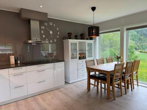 a kitchen with a table and chairs and a clock on the wall at Loen Panorama View in Loen