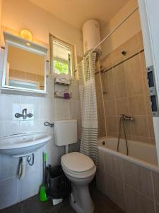 a bathroom with a toilet and a sink and a tub at High Hostel in Budva