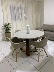 a white table and chairs in a living room at Apartamento 3 min do FIG in Garanhuns