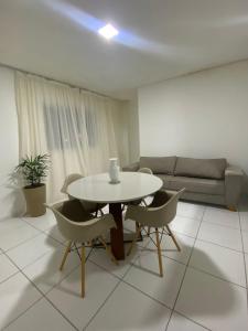 a living room with a table and chairs and a couch at Apartamento 3 min do FIG in Garanhuns