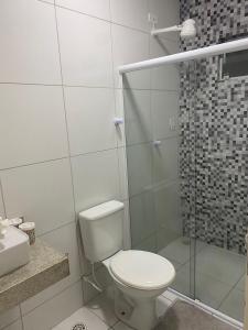 a white bathroom with a toilet and a shower at Apartamento 3 min do FIG in Garanhuns