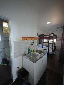 a small kitchen with a sink and a bathroom at High Hostel in Budva