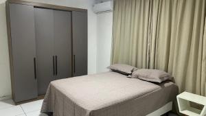 a small bedroom with a bed and a closet at Apartamento 3 min do FIG in Garanhuns