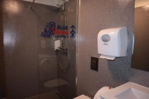 a bathroom with a shower with a toilet and a sink at Blue Viking Pods in Keflavík