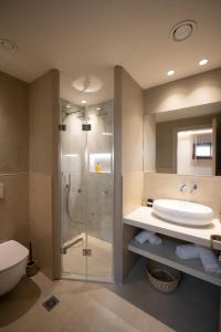 a bathroom with a shower and a sink and a toilet at Parga Harbor Suites in Parga