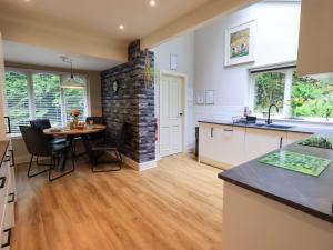 a kitchen and dining room with a table and a brick wall at Underheron in Grasmere
