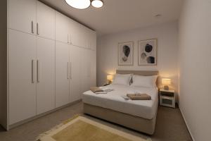 a white bedroom with a bed and white cabinets at Olive Residence in Skala Fourkas +33 photos