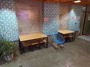 a room with two tables and a blue chair at Hotel Momotus Tuxtla - Desayuno opcional in Tuxtla Gutiérrez