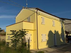 a yellow building with a shadow on the side of it at PAO Elena Resort in Monterubbiano