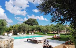 a swimming pool with a table and chairs in a yard at AD&DIMORE L'ANTICO TRULLO in Polignano a Mare