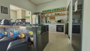 a large kitchen with a counter and a sink at Casa Tô D`Boa Capitólio in Capitólio