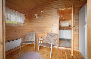 ein hölzernes Zimmer mit zwei Stühlen und einem Tisch in der Unterkunft Maxi Cabin with Sauna and Jacuzzi in Kovan