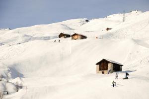 a group of people skiing down a snow covered mountain at Grosshus Vals in Vals