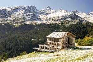 een oud huis op een heuvel met bergen op de achtergrond bij Grosshus Vals in Vals