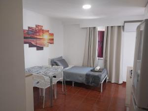 a small room with a bed and a table and chairs at Casa Santa Maria apartamento B in Ermidas