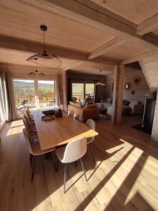 a dining room with a wooden table and a bedroom at Chalet d'exception avec jacuzzi sauna et piscine - proche station du retord in Sainte-Blaizine +24 photos