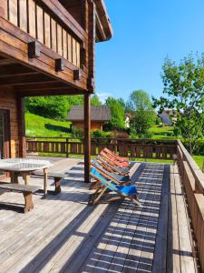 a deck with a picnic table and chairs and a table at Chalet d'exception avec jacuzzi sauna et piscine - proche station du retord in Sainte-Blaizine