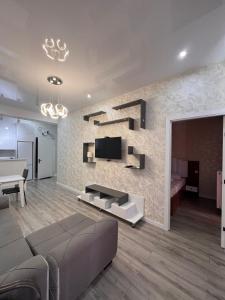 Una sala de estar con un sofá y un televisor en una pared. en New comfort class apartments, en Kutaisi