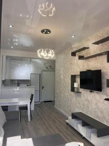 Una sala de estar con una mesa y un televisor en una pared. en New comfort class apartments, en Kutaisi