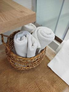 a basket of towels sitting on the floor in a bathroom at Ático premium con vistas al mar y a la laguna del Salar in Vera