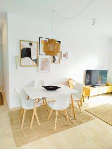 a white dining room with a white table and chairs at Ático premium con vistas al mar y a la laguna del Salar in Vera