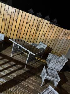 a table and chairs on a deck with a wooden fence at Four Bedroom House ,Bundoran ,county Donegal in Balnacart