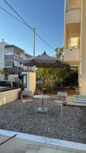 a table and chairs with an umbrella in front of a building at The Mulberry House Heritage by the Sea in Alexandroupoli +32 photos