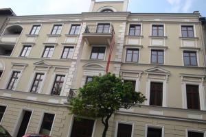a building with a tree in front of it at Apartament Kopernik in Kraków
