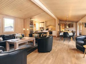 ein Wohnzimmer mit Sofa, Stühlen und einem Tisch in der Unterkunft 4 star holiday home in Væggerløse in Bøtø By