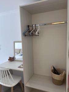 a room with a closet with hangers and a desk at Andromeda Seaside Apartments in Vlikhón +26 photos