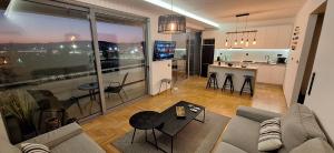 a living room with a couch and a table and a kitchen at Vip Panoramic view in Athens