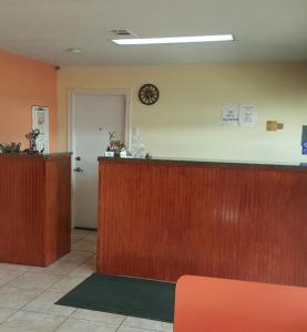 a waiting room with a counter and a clock on the wall at Budget Inn in Coleman