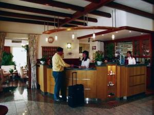 a man standing at a bar in a restaurant at Hotel Perekop in Berdorf