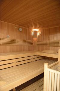a sauna with wooden walls and benches and a clock at Gasthof Enzian in Tannheim