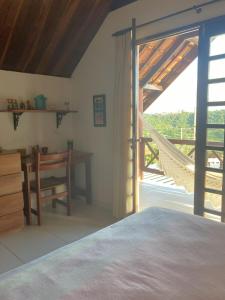 a bedroom with a bed and a table and a window at Condomínio Serra Nevada - Chalé 202 in Bananeiras