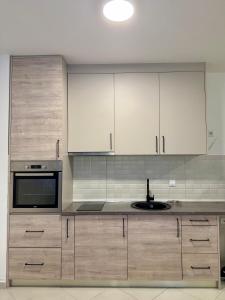 a kitchen with white cabinets and a sink at Apartman Dunja Bečići in Becici