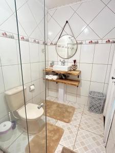 a bathroom with a toilet and a sink and a mirror at Casa Sobre as Nuvens - Ideal para Casal ou Família in Campos do Jordão +12 photos