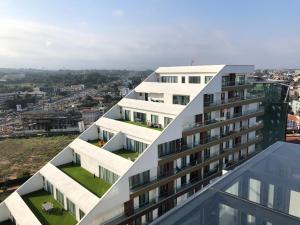 an apartment building with a view of a city at RoyalRest at Signature CPG in Accra