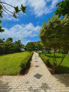 un sentiero in mattoni in un parco con un albero di Blue Villa Wadduwa a Wadduwa Altre 4 foto