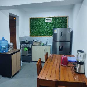 a kitchen with a wooden table and a refrigerator at Hospedaje Velilu in Ica