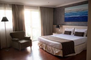 a hotel room with a bed and a chair at BFC Suíte em Barra da Tijuca in Rio de Janeiro +34 photos