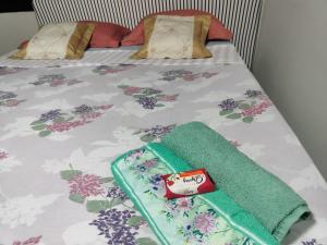 a bed with a bedspread with flowers on it at Pousada Canto dos Pássaros in Cianorte