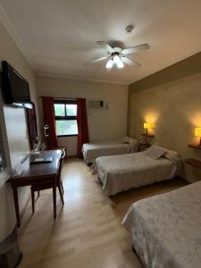 a hotel room with two beds and a ceiling fan at Hotel Escala Uno in Santo Tomé