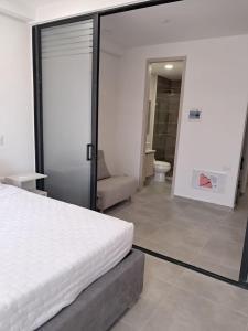 Un dormitorio con una cama blanca y un baño. en Tropical Oasis Suite, en Santa Marta