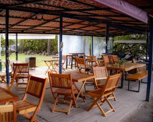 a group of wooden tables and chairs on a patio at BFC Suíte em Barra da Tijuca in Rio de Janeiro