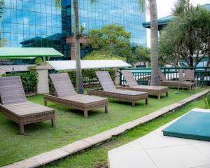 a group of chairs sitting on the grass in front of a building at BFC Suíte em Barra da Tijuca in Rio de Janeiro